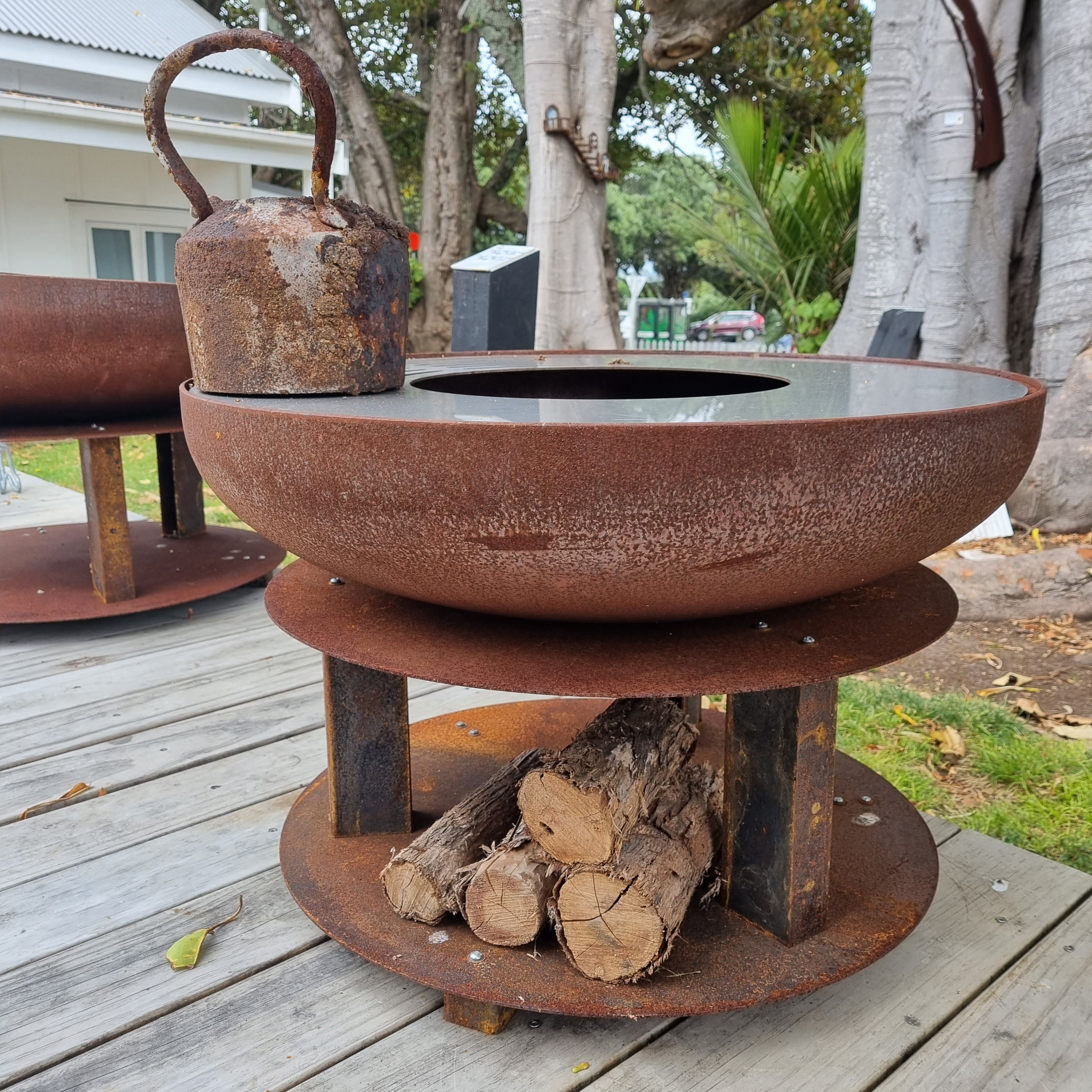 The Awhitu 750 Fire Bowl with woodstorage and cooktop